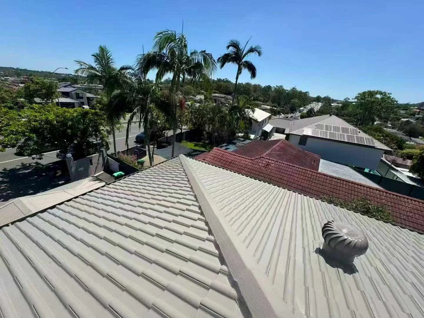 Wide Ellis roof work photo showing grey roof tiles, ridge caps and a roof vent